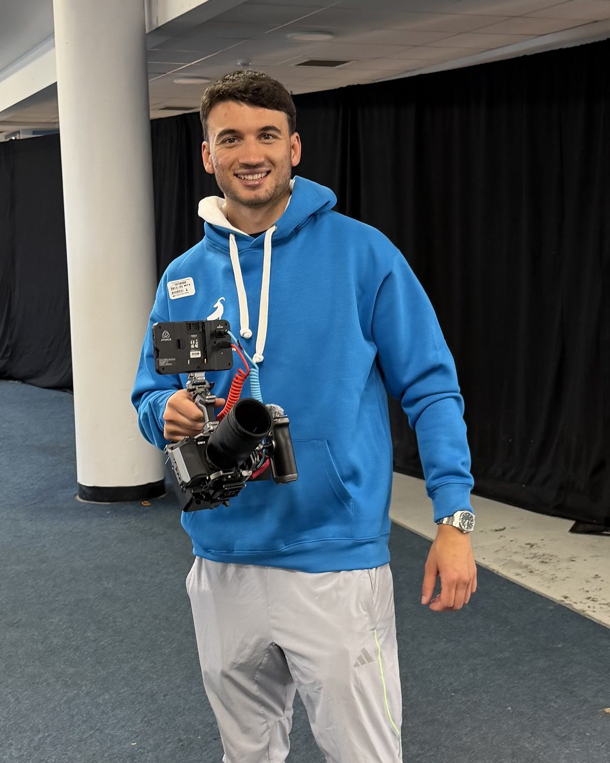 Emanuel Andrei at an event, smiling, holding his camera on a gimbal
